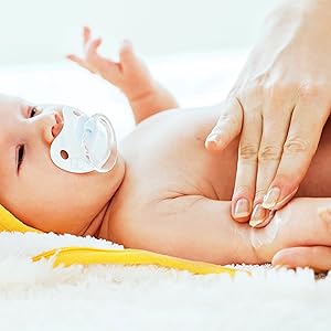 Mom applying baby oil on a babe