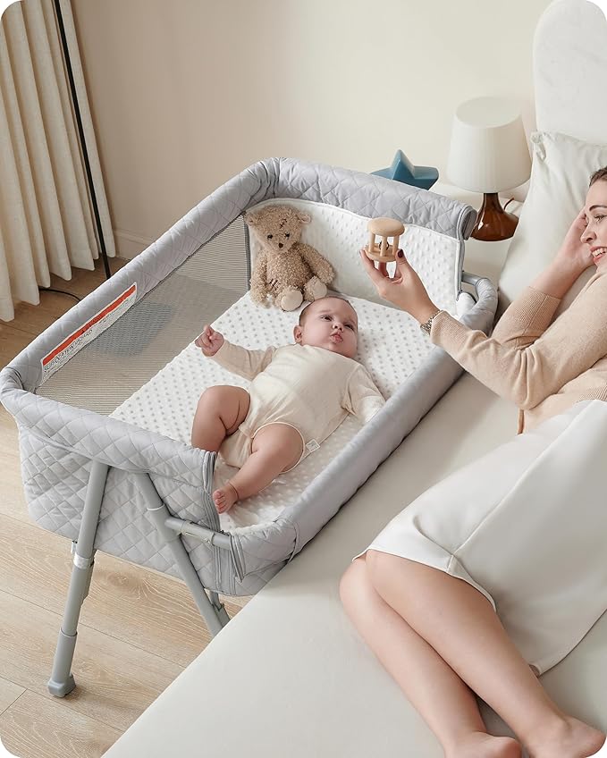 Baby in baby bassinet playing with mom